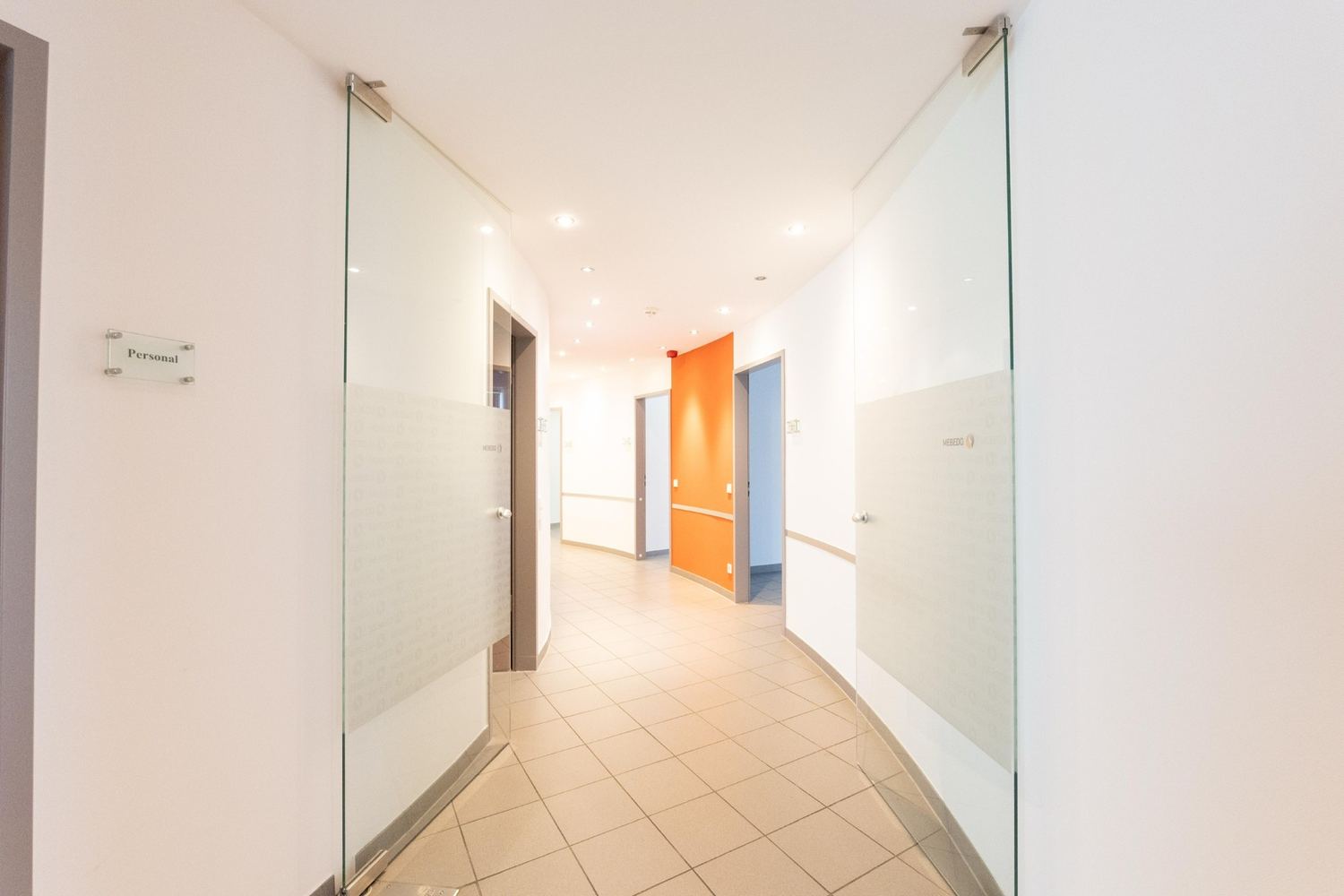 Gebogener Flur der Praxisetage im 2. Obergeschoss mit Glastüren und runder Wandführung