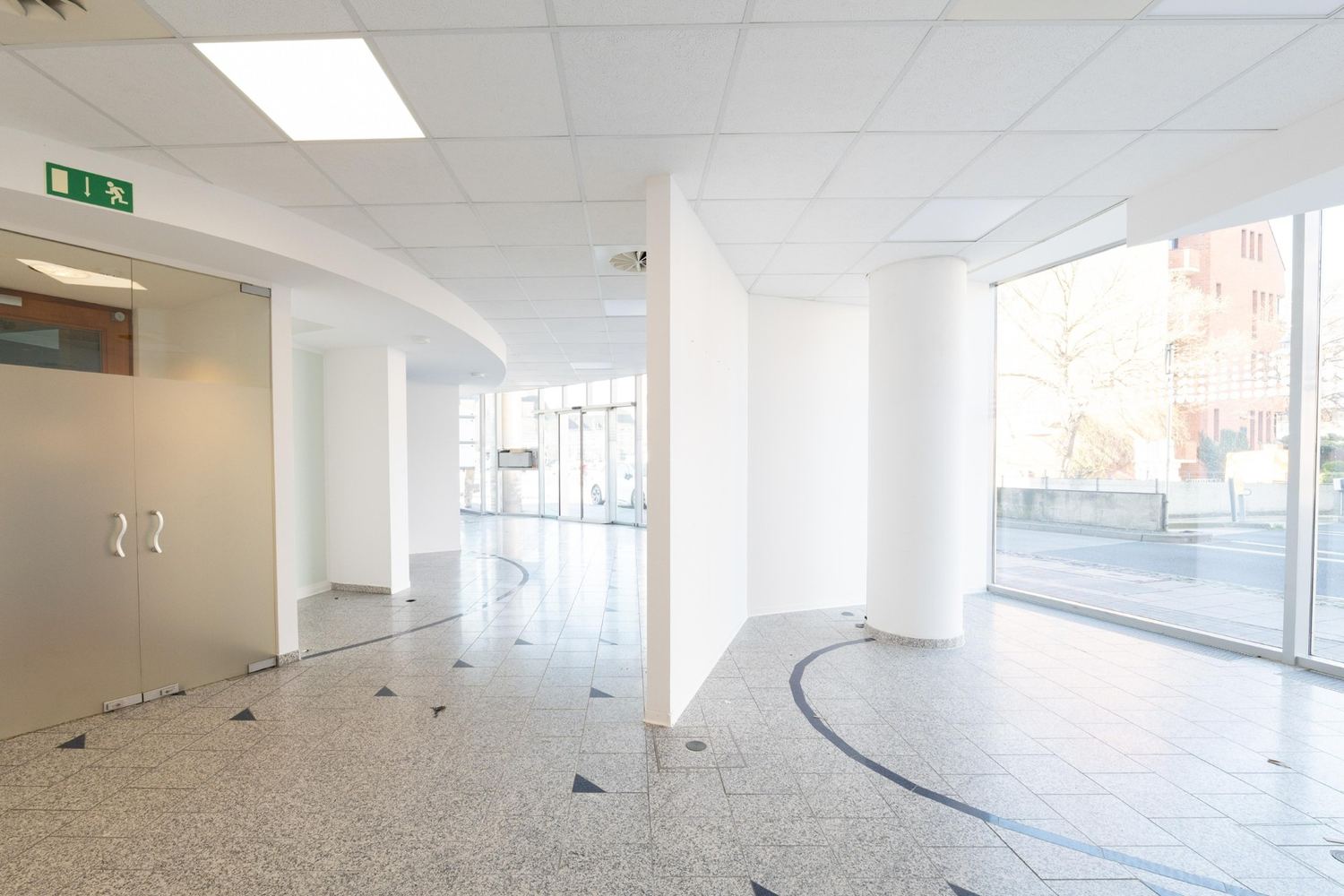 Eingangsbereich der Erdgeschoss-Gewerbeeinheit mit großzügiger Glasfront zum Bahnhofplatz
